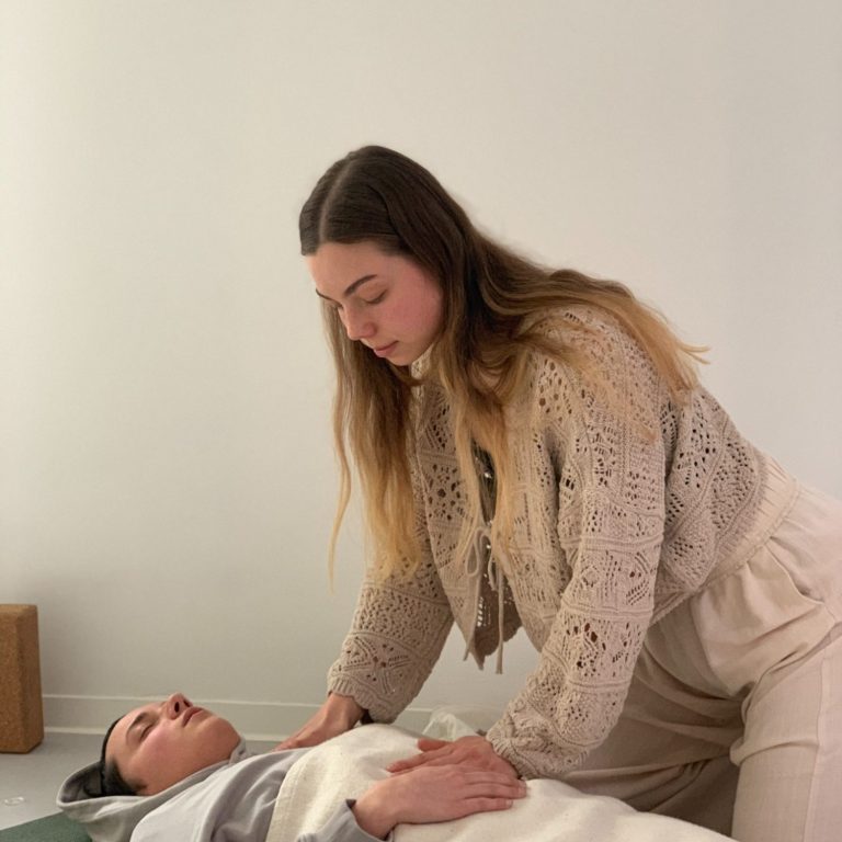 Emi begleitet eine liegenden Person in einem Breathwork Prozess.